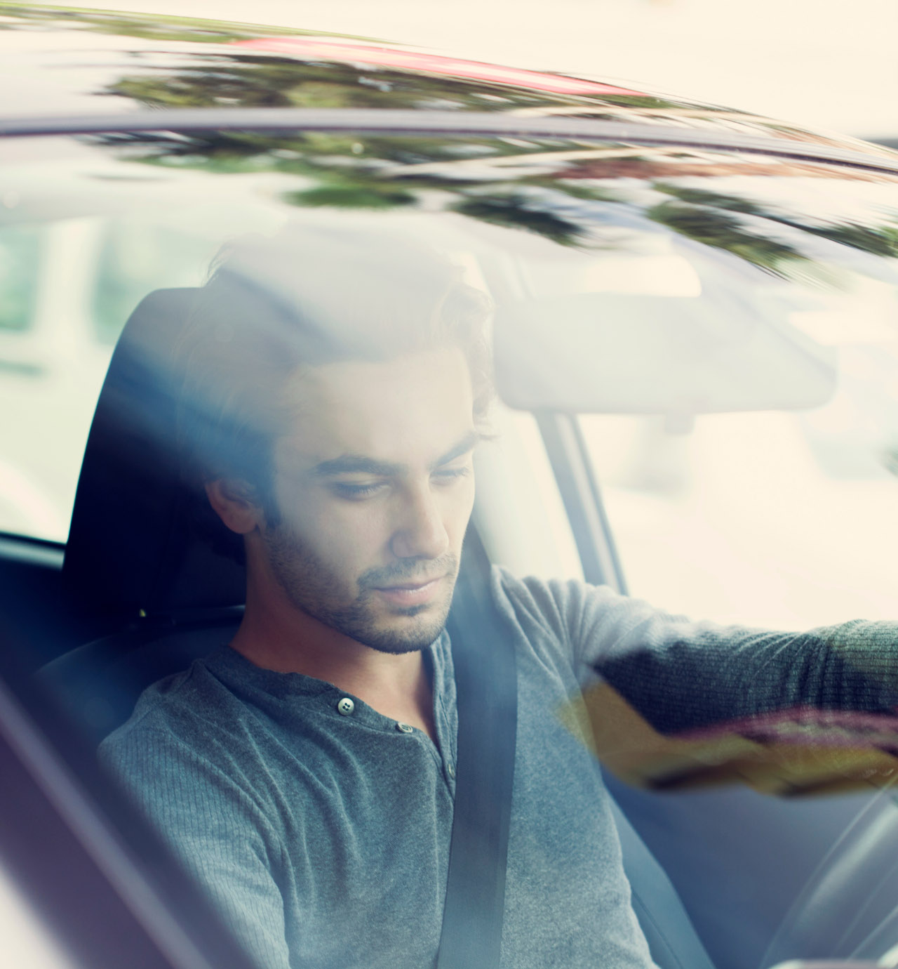 Man driving a car looking through windshield