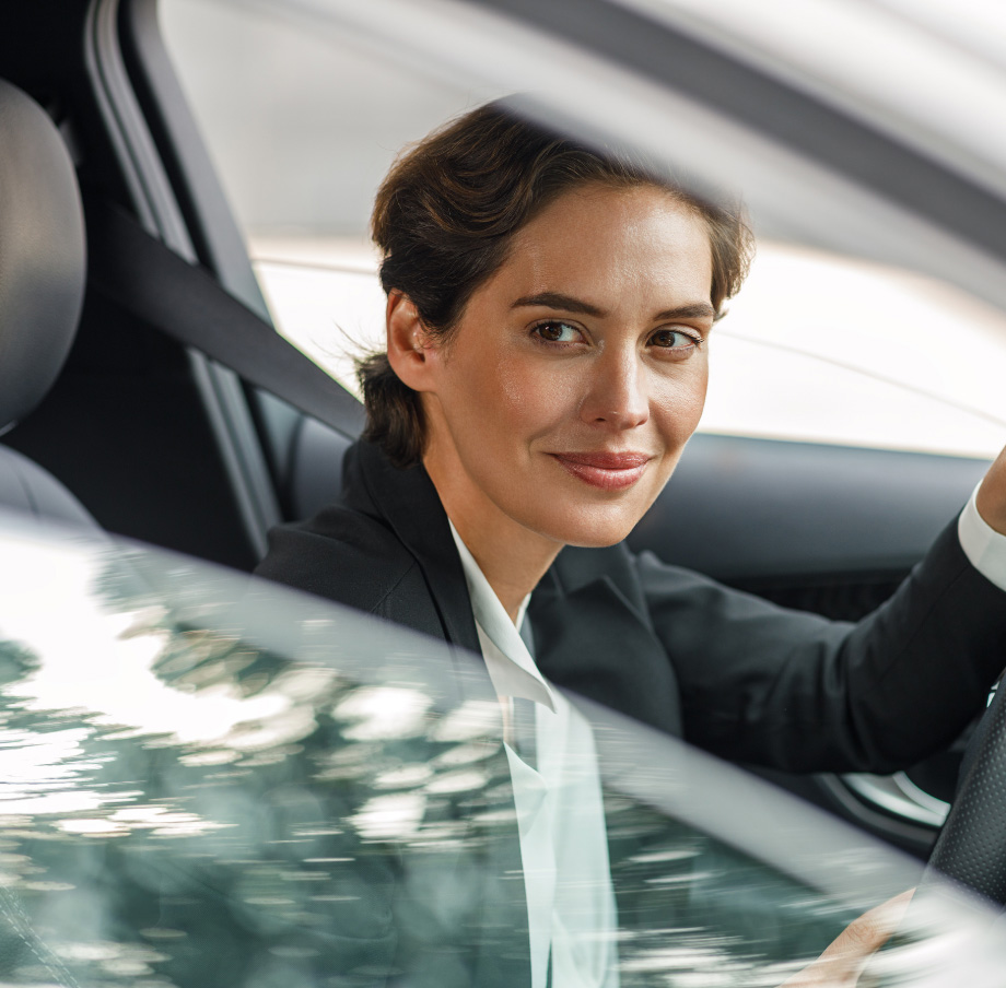 Mujer viendo a través de la ventana desde un carro.